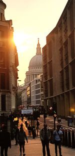 People walking on street amidst buildings in city