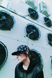 Rear view of young woman standing against wall