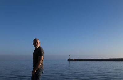 Adult man against sea and sky with lighthouse in background. almeria, spain