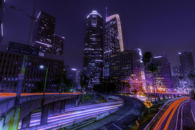 High angle view of illuminated street amidst buildings at night