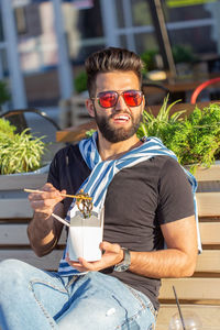 Young man wearing sunglasses sitting on table