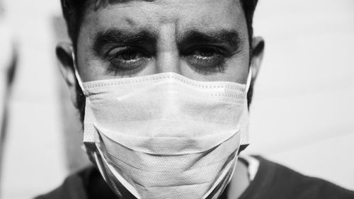 Close-up portrait of young man wearing surgical face mask
