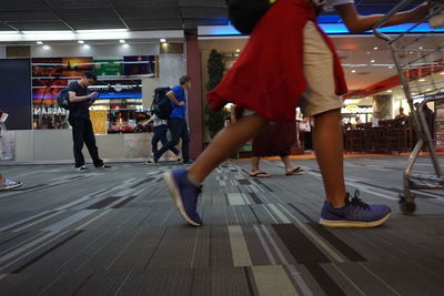 People walking on illuminated road in city at night