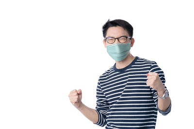 Portrait of young man standing against white background