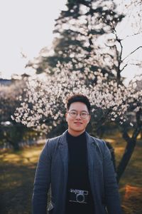 Portrait of young man standing against plants