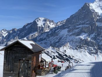 Houses by snow covered mountains against sky