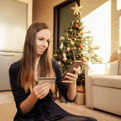 Young woman using mobile phone at home