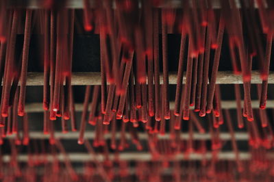 Full frame shot of red incense sticks hanging