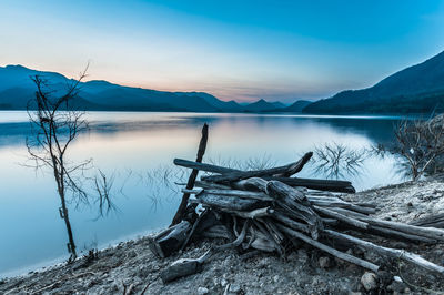 Scenic view of lake by mountains against sky