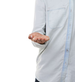 Midsection of doctor holding dentures against white background