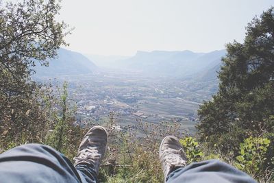 Low section of man standing on landscape against sky