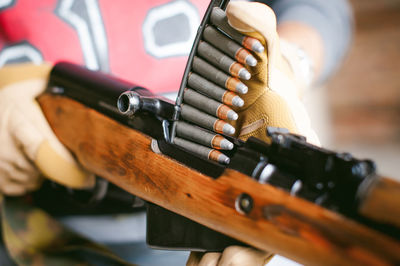 Midsection of man holding rifle