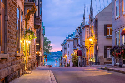 Street amidst buildings in city at night