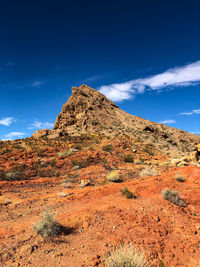 Low angle view of rocky mountain against blue sky