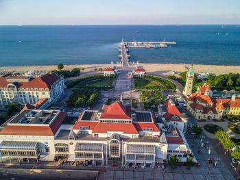 High angle view of buildings by sea against sky
