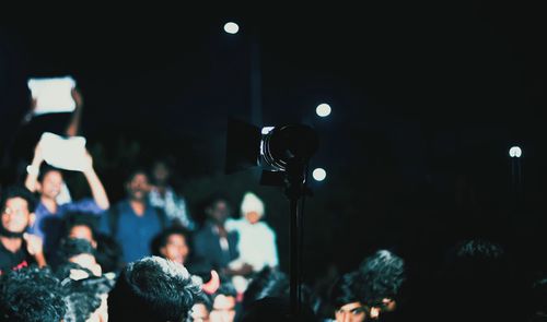 People photographing at music concert during night