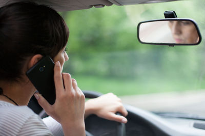 Woman talking on smart phone while sitting in car