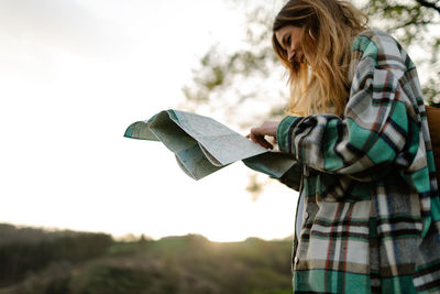 Midsection of woman holding umbrella against sky