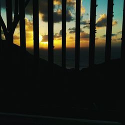 Close-up of silhouette built structure against sunset sky