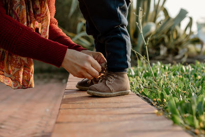 Low section of man standing on boardwalk