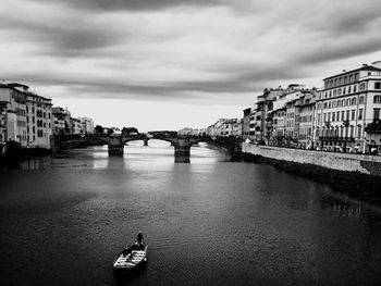 Bridge over river in city against sky