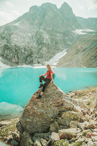 Man on rock by mountains