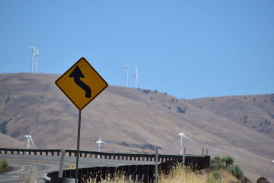 Road sign against clear blue sky