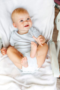 High angle view of cute baby boy sleeping on bed at home