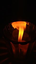 Close-up of burning candle in darkroom