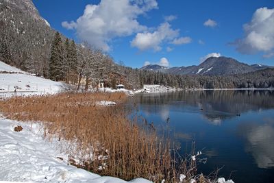 Scenic view of lake by snowcapped mountains against sky