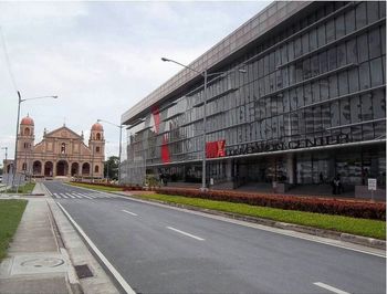 Road by buildings against sky