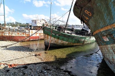 Boat moored on beach against sky