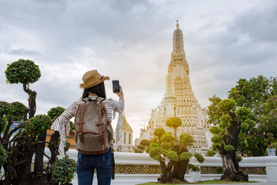 Rear view of woman standing against temple