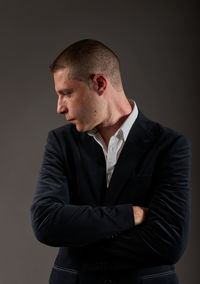 Young man standing against black background