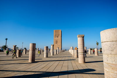 Tourists at beach against clear blue sky