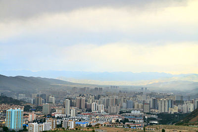 Cityscape against cloudy sky