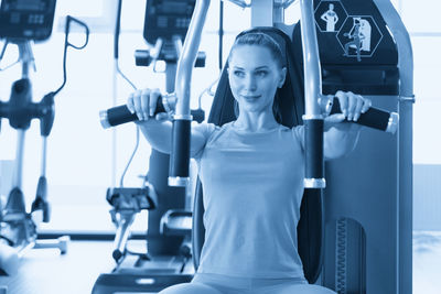 Portrait of young woman exercising in gym