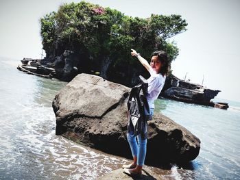 Full length of boy on rock at sea shore