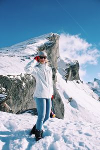 Full length of woman standing on snowcapped mountain