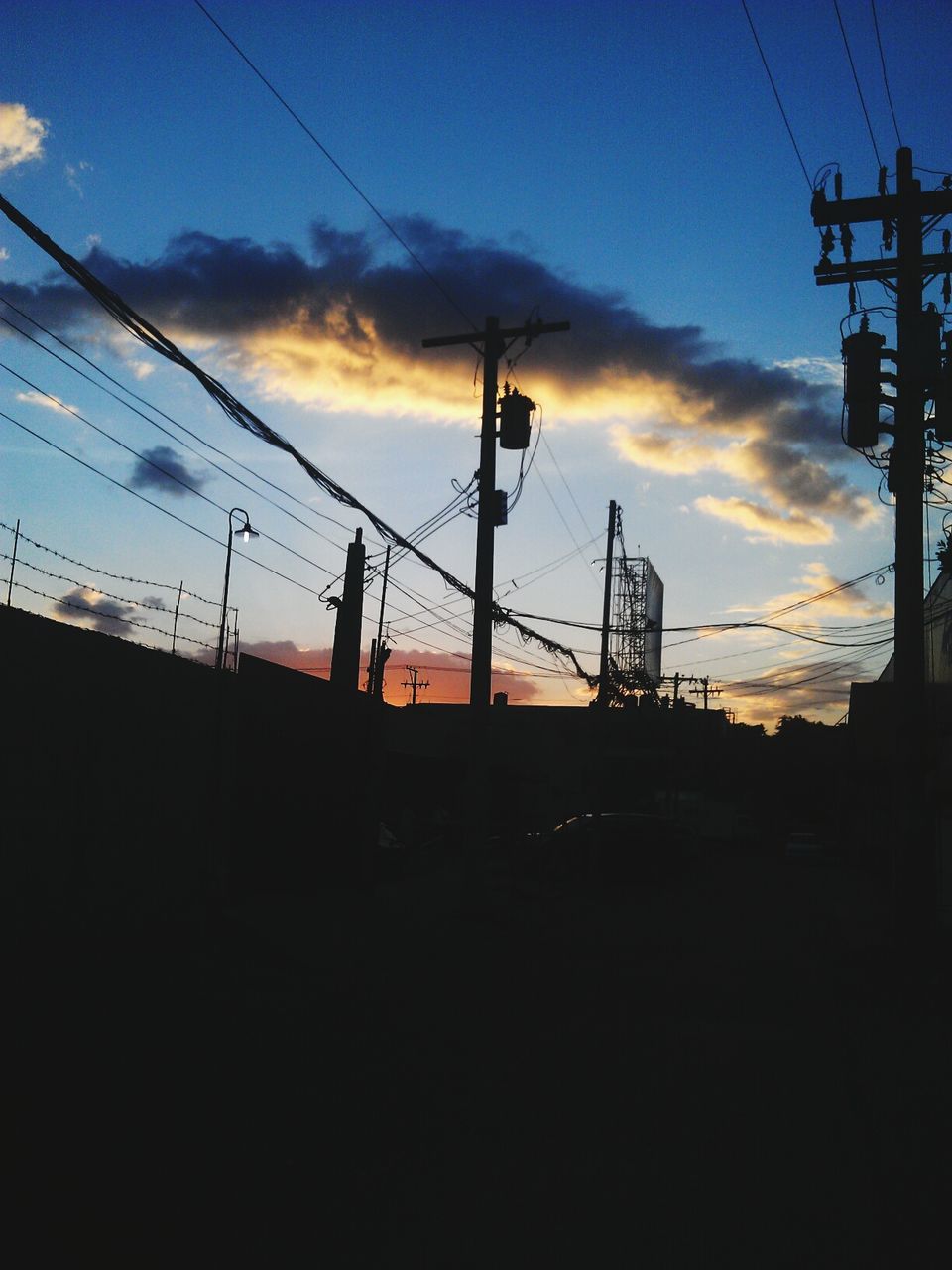 power line, electricity pylon, power supply, electricity, sunset, connection, silhouette, cable, sky, fuel and power generation, low angle view, technology, built structure, power cable, architecture, cloud - sky, building exterior, dusk, cloud, outdoors