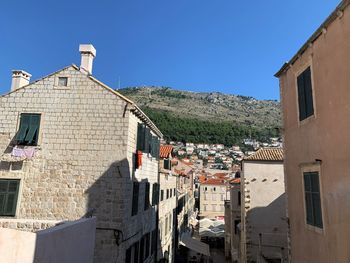 Buildings in town against clear blue sky