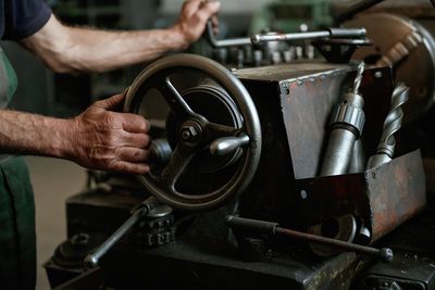 Cropped hands of man repairing machine part