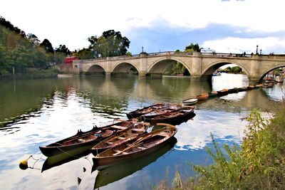 Arch bridge over river against sky