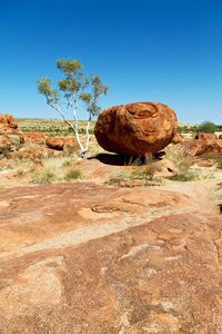 Rock formations on landscape against clear blue sky