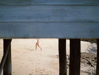 Low section of woman walking at beach