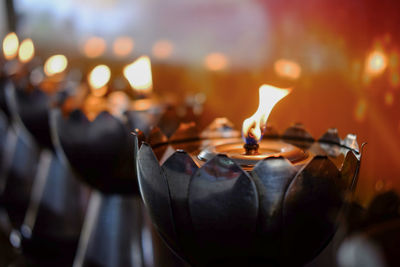 Close-up of lit candles in temple
