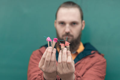 Portrait of young man holding leaf