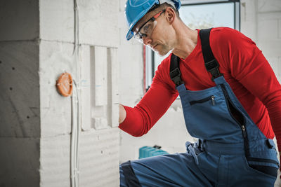 Side view of man looking through window