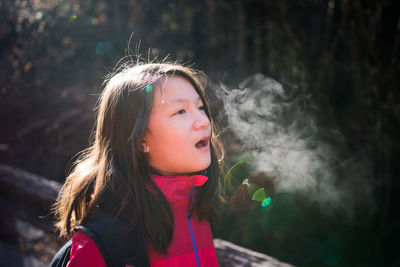 Close-up of girl standing against blurred background