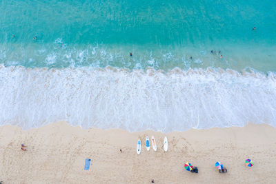 Aerial view nature landscape ocean wave foam on the sand beach and travel tourists at surin beach 